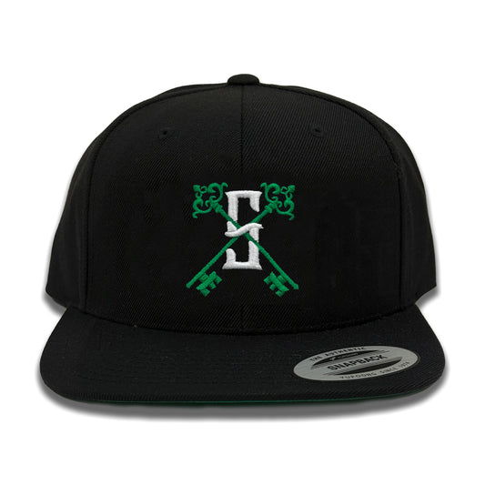 A Syndictate Key X black snapback cap with a green logo and decoration
